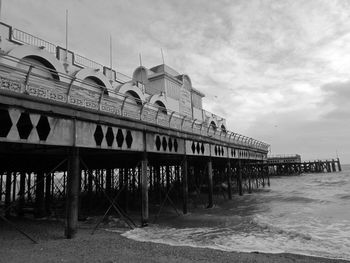 Built structure on beach by sea against sky