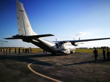 Airplane on airport runway against sky