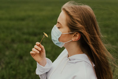 Young woman blowing bubbles on field