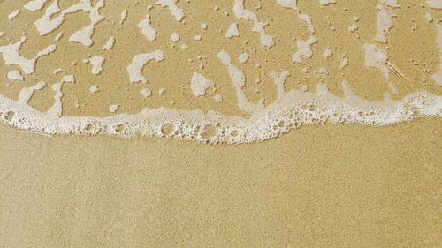 Close-up of text on sand