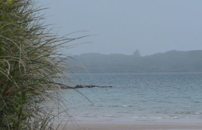 View of calm sea against mountain range