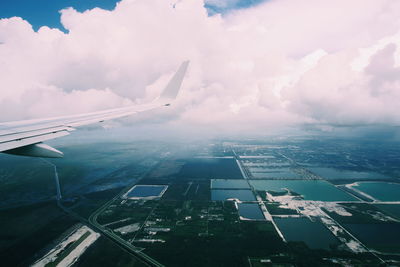 Aerial view of airplane wing over sea against sky in florida