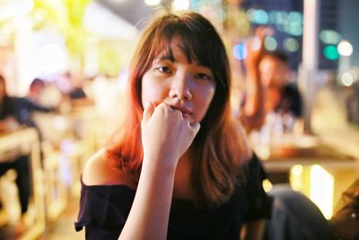Portrait of woman eating food at restaurant looking straight to the camera