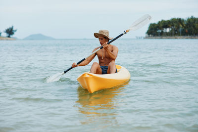 Man kayaking in sea