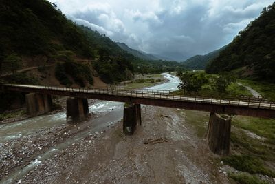 Bridge over mountain against sky