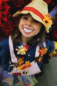 High angle portrait of playful girl wearing hat and artificial teeth