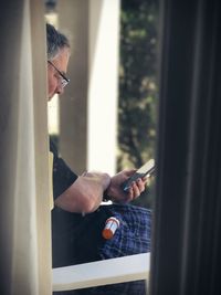 Midsection of man holding window