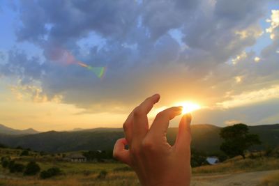 Cropped image of man looking at sunset