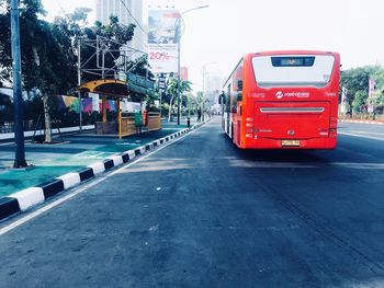 Red car on road against sky in city