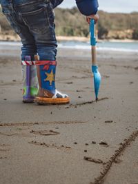 Low section of man standing on beach