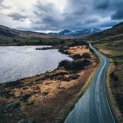 Scenic view of road by mountains against sky
