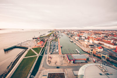 High angle view of cityscape by sea against sky