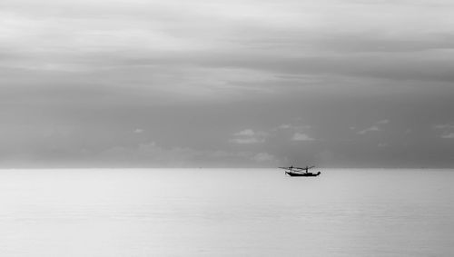 Boat sailing on sea against sky
