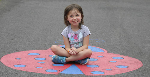 Portrait of a smiling girl sitting outdoors