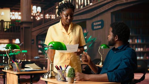 Side view of young woman holding drink at home