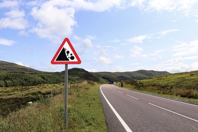 Road sign against sky