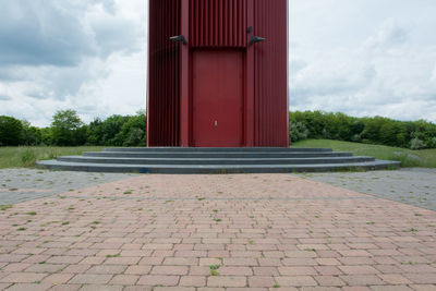 Red brick wall against cloudy sky
