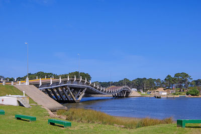 Bridge over river against blue sky