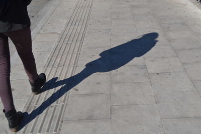 Low section of woman standing on tiled floor