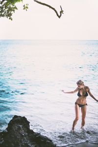 Silhouette of woman jumping in sea