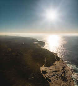 Scenic view of sea against bright sun