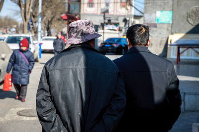 Rear view of people walking in city