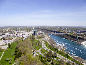 High angle view of cityscape by sea against sky