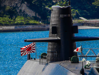 Close-up of red flag on railing by lake