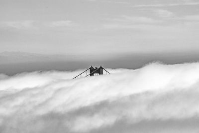 Tip of the golden gate bridge peeking through the fog