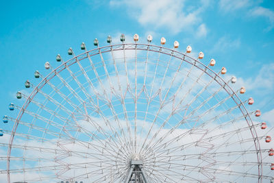 Low angle view of ferris wheel against cloudy sky