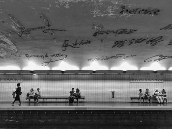 People on illuminated wall against sky