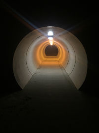 Illuminated tunnel at night