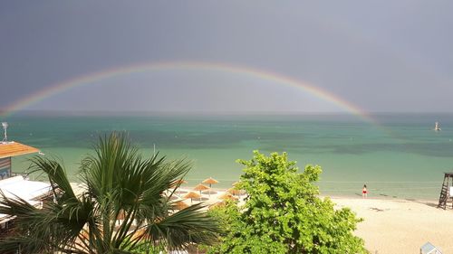 Scenic view of rainbow over sea against sky