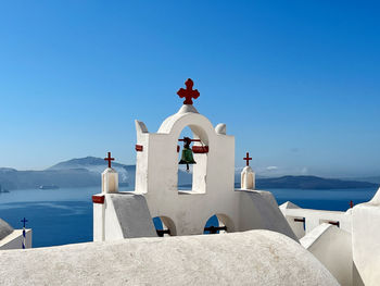 Greek church  by sea against clear blue sky