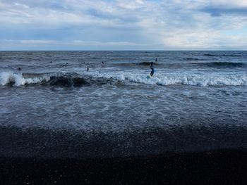 Silhouette man standing on beach against sky