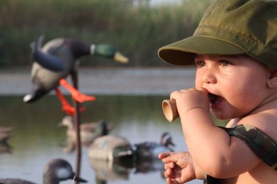 Baby boy wearing cap at lakeshore