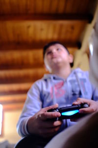 Boy holding video game remote control at home