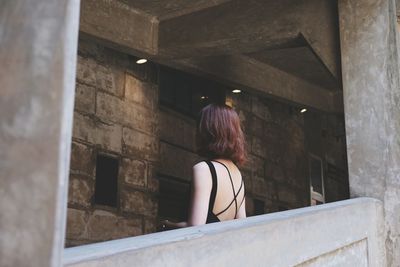 Rear view of woman standing in corridor