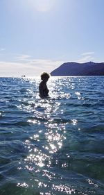 Man swimming in sea against sky