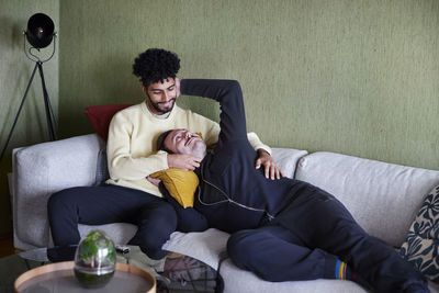 Gay couple relaxing on sofa at home