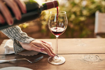 Midsection of woman holding wineglass