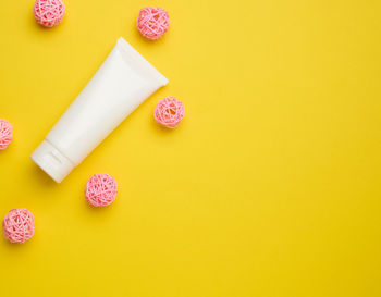 Empty white plastic tubes for cosmetics on a yellow background. packaging for cream, gel, 