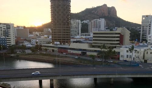 Buildings in city against sky during sunset