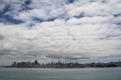 Scenic view of sea by buildings against sky