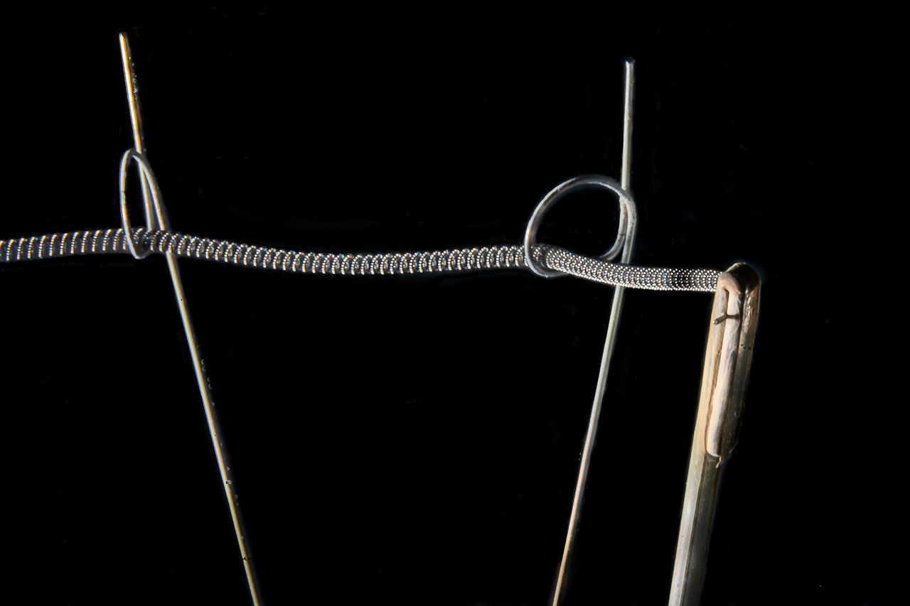 LOW ANGLE VIEW OF ROPE AGAINST BLACK BACKGROUND