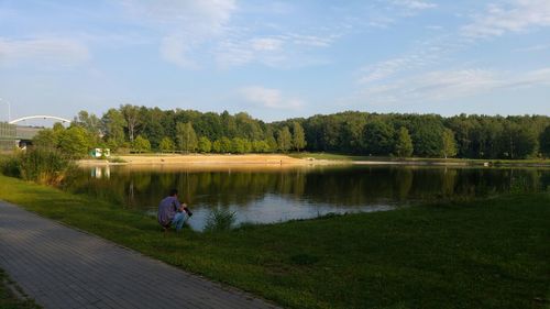 Scenic view of lake by trees against sky