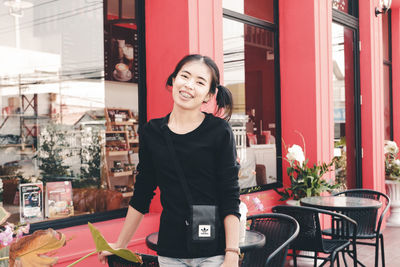 Portrait of smiling young woman standing outdoors