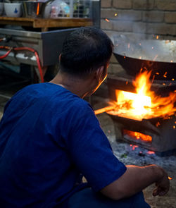 Rear view of man preparing food in kitchen