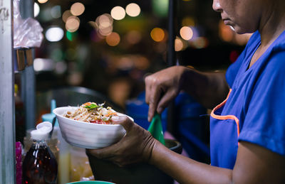 Midsection of woman holding food at restaurant table