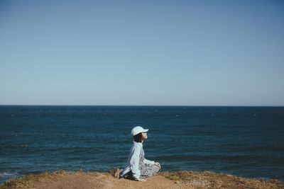 Woman looking at sea against clear sky